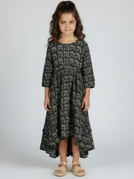 Young girl wearing a black floral dress on a white background