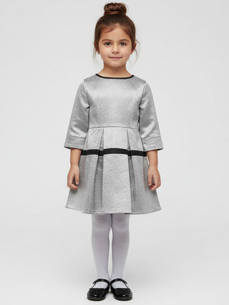 Young girl wearing a gray dress with black trim on a white background