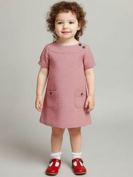 Child wearing a Young girl wearing a red houndstooth dress with red shoes on a gray background