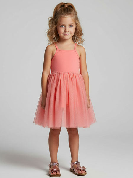 Young girl wearing a pink dress against a plain background