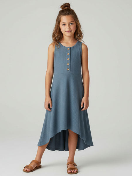 Girl wearing a blue dress with buttons on a white background