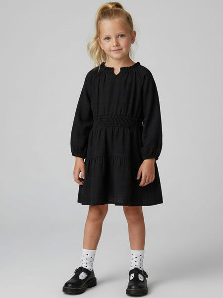 Young girl wearing a black dress on a plain background