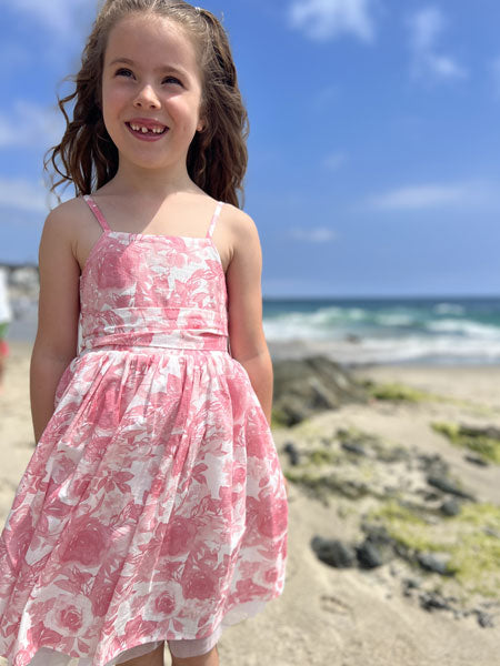 Sleeveless, thin straps, girls party dress in a pink roses print by Vignette. Soft mesh white tulle at hem.