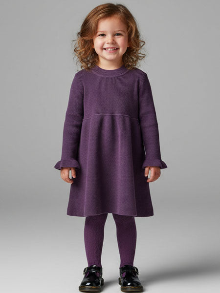 Young girl wearing a purple dress against a gray background