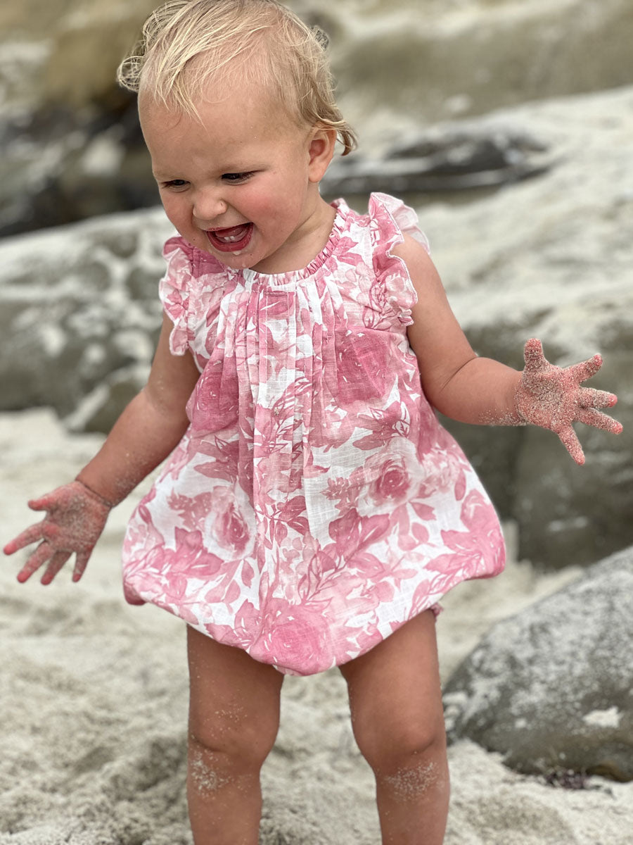 Sleeveless baby girls bubble romper in a pink roses print, the Tamsin Bubble by Vignette.