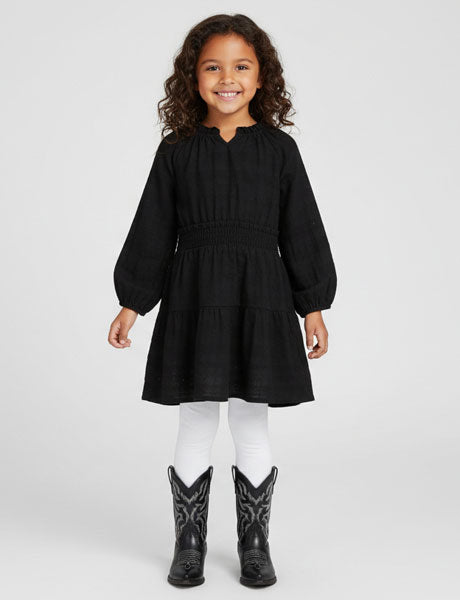 Young girl wearing a black dress and black boots on a white background