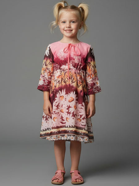 Young girl wearing a floral dress on a gray background