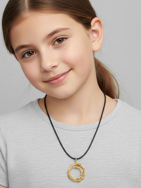 Young girl wearing a necklace with a gold pendant on a plain background