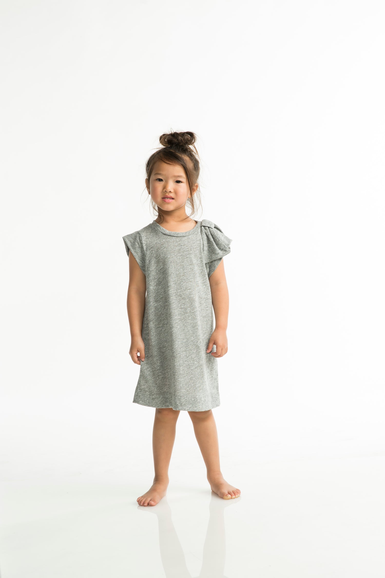 Young girl wearing a gray dress on a white background