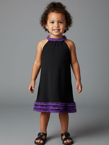 Toddler girl wearing a black dress with purple trim against a gray background