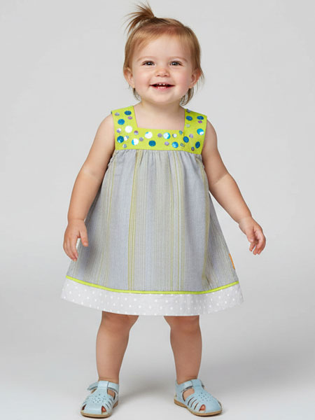 Child wearing a polka dot dress with a plain background