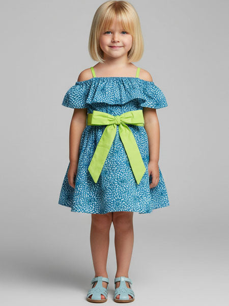 Young girl wearing a blue dress with a green bow on a gray background