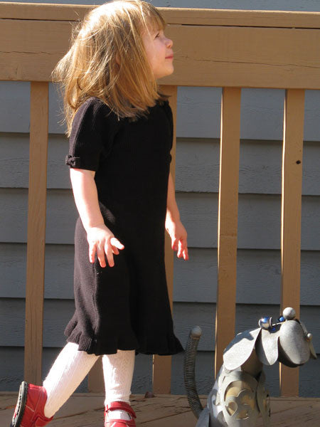 Girls black dress, sweater knit style. Short sleeves with bows, ruffle at hem line, and cute scalloped neckline.