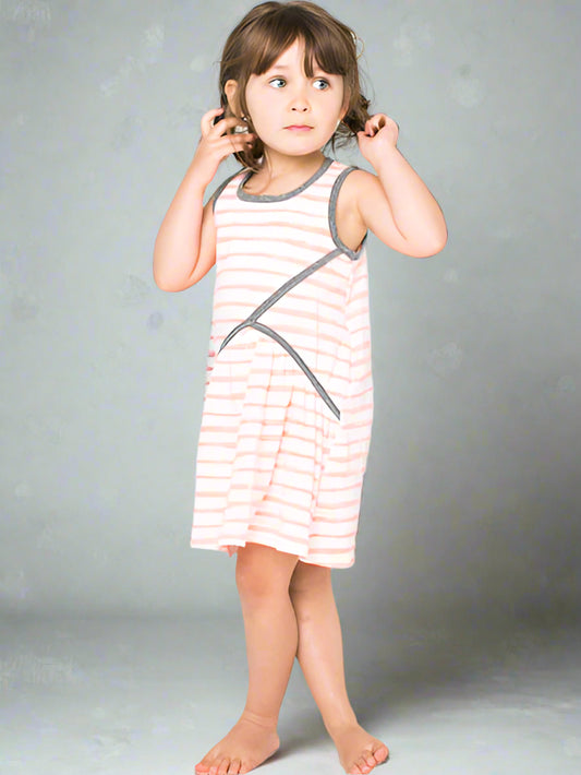 Young girl wearing a striped dress against a gray background