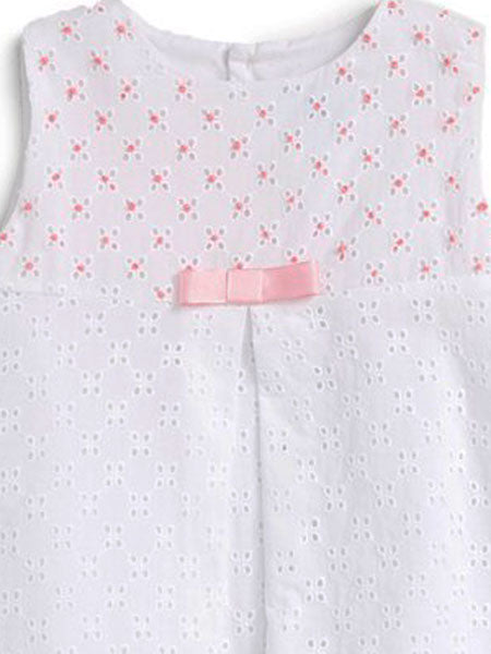 Detail image of  A-line white eyelet dress with center pleat for baby girls. Pink accents on upper bodice, small pink bow.