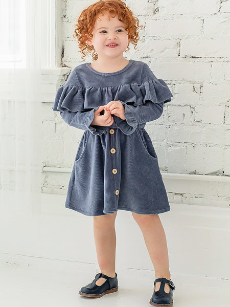 Blue corduroy girls party dress by Mable + Honey. Ruffle trim at yolk and sleeves. Decorative front buttons.