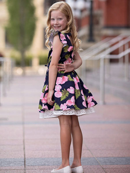 Navy and pink print girls summer party dress. Ruffle trim on sleeveless arm top. Cute white petticoat borders dress. Mabel + Honey brand.