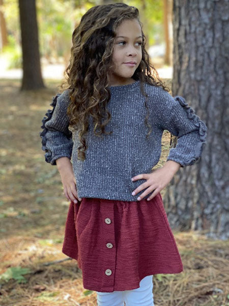 Little girl wearing rust skirt and gray sweater top.  Gathered elastic waist. Front faux center plaquette with brown button at center.